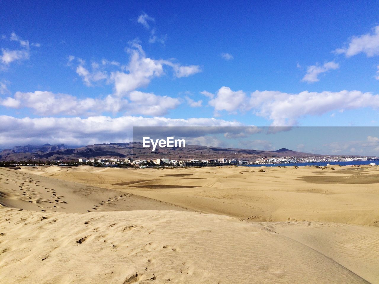 Scenic view of dunas de maspalomas against blue sky