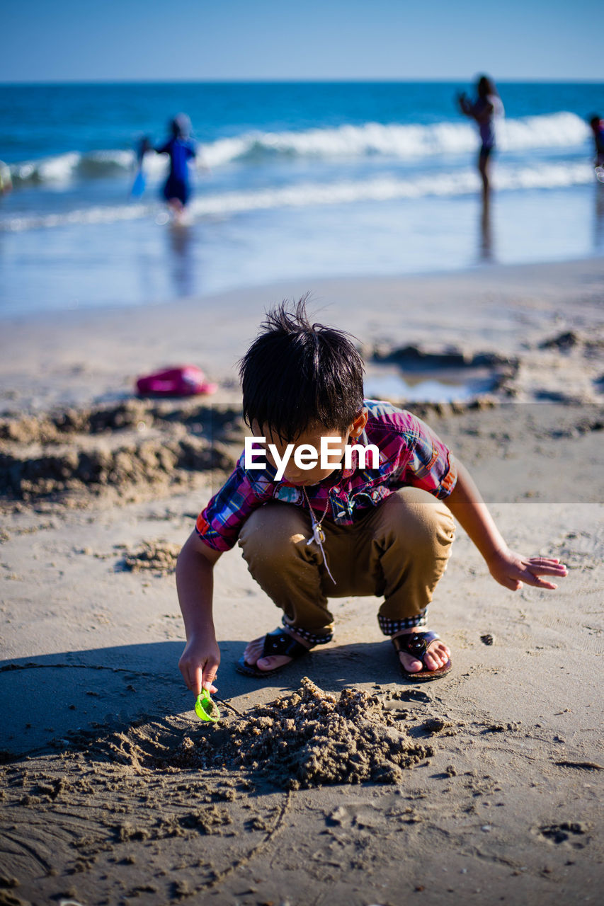 Boy playing on sand at beach