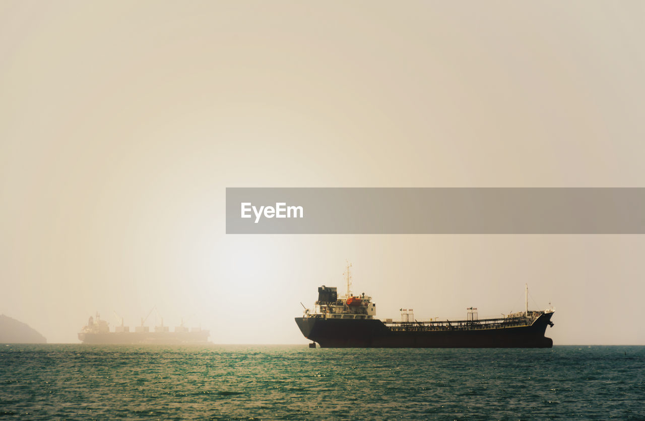 SHIP SAILING IN SEA AGAINST CLEAR SKY