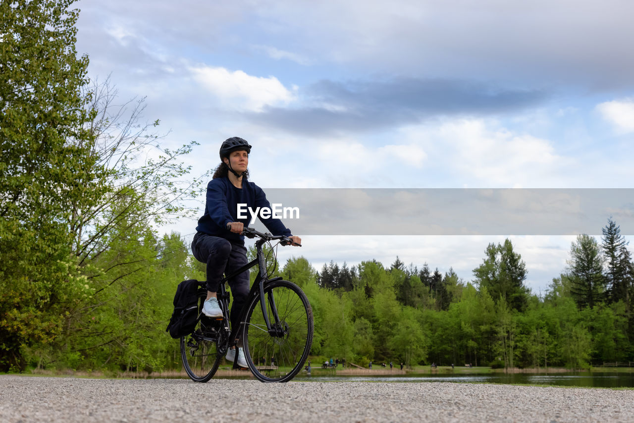 FULL LENGTH OF MAN RIDING BICYCLE ON PLANTS