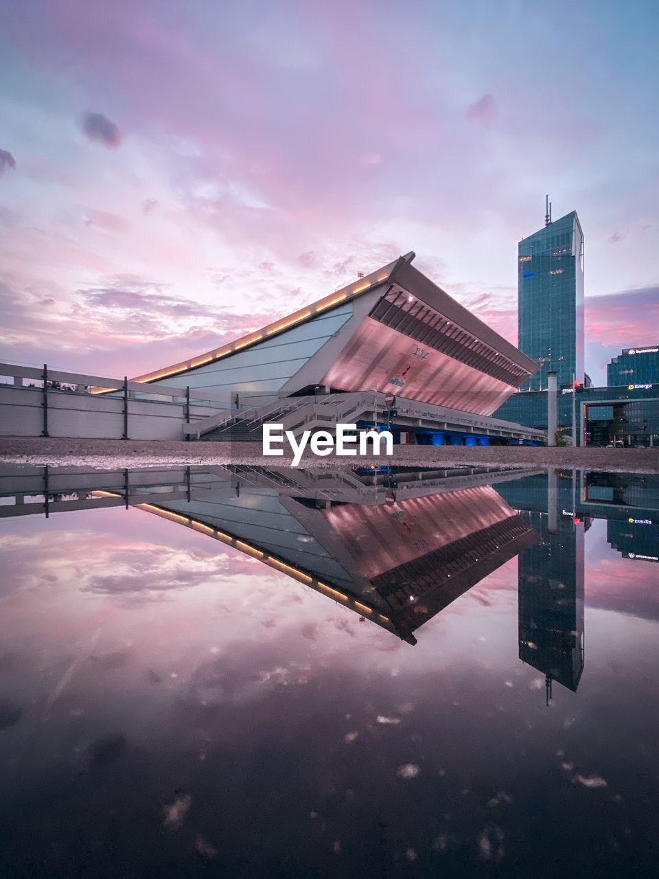 REFLECTION OF BUILDING IN LAKE AGAINST SKY