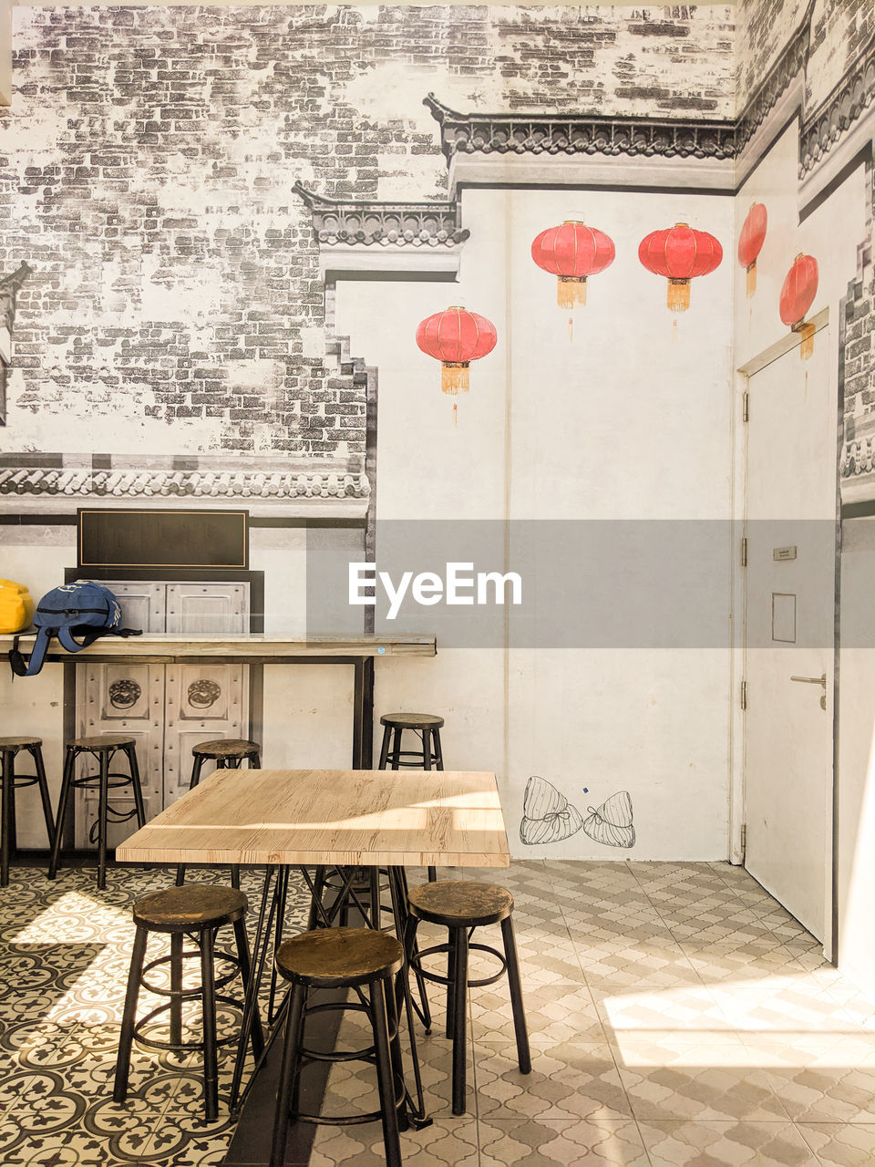 EMPTY CHAIRS AND TABLES AGAINST WALL IN BUILDING