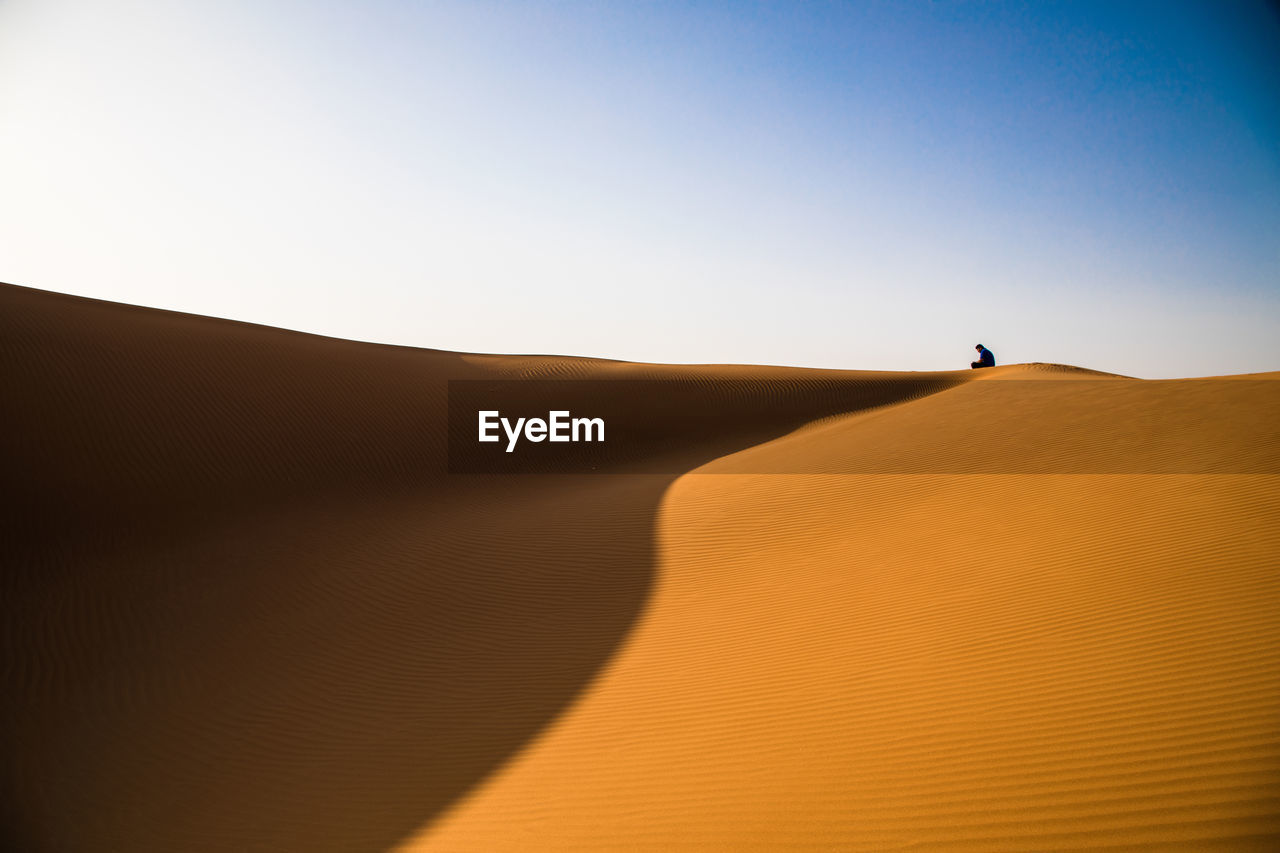 A man  on the dune in the desert