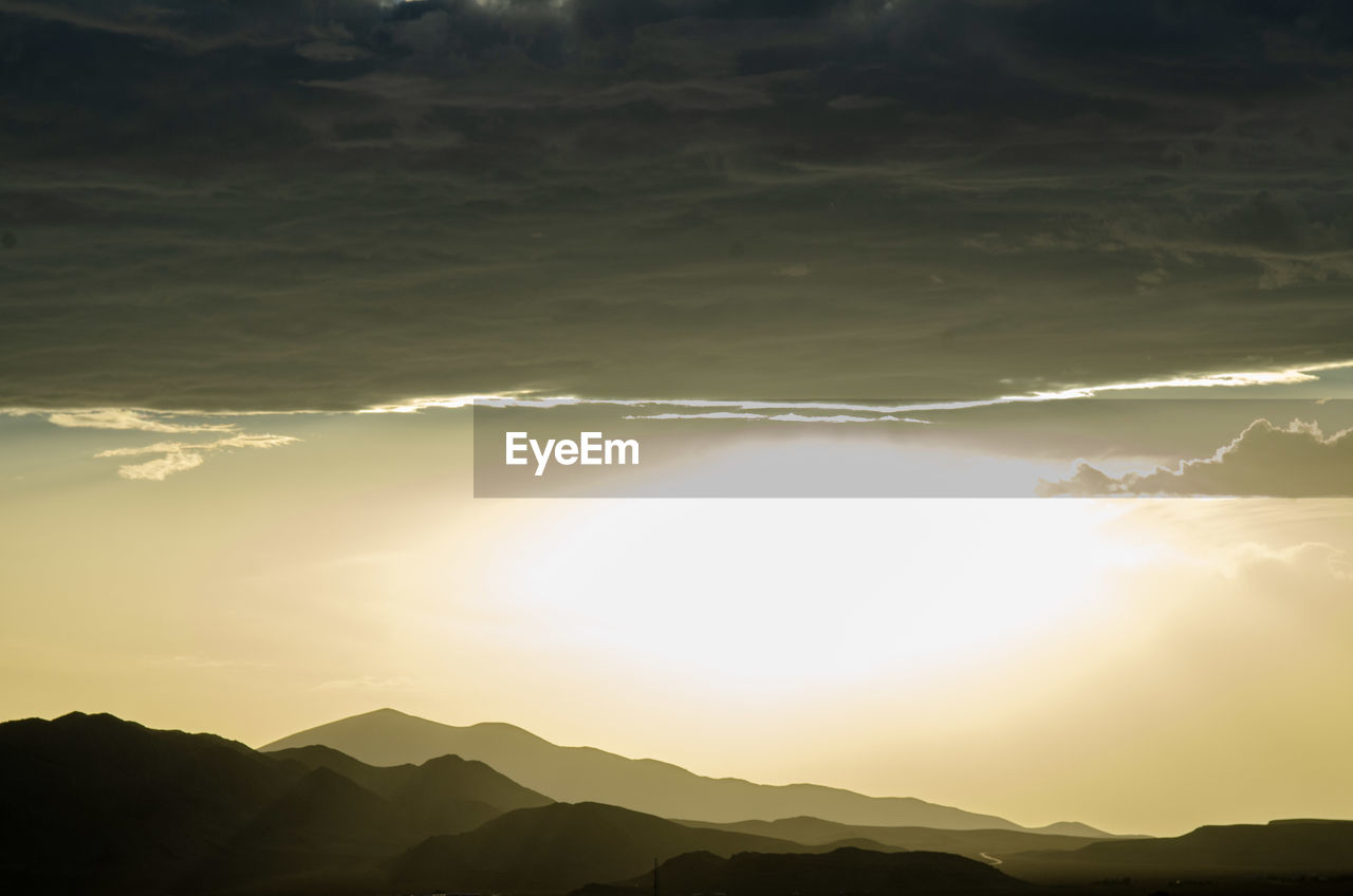 Scenic view of silhouette mountains against sky during sunset