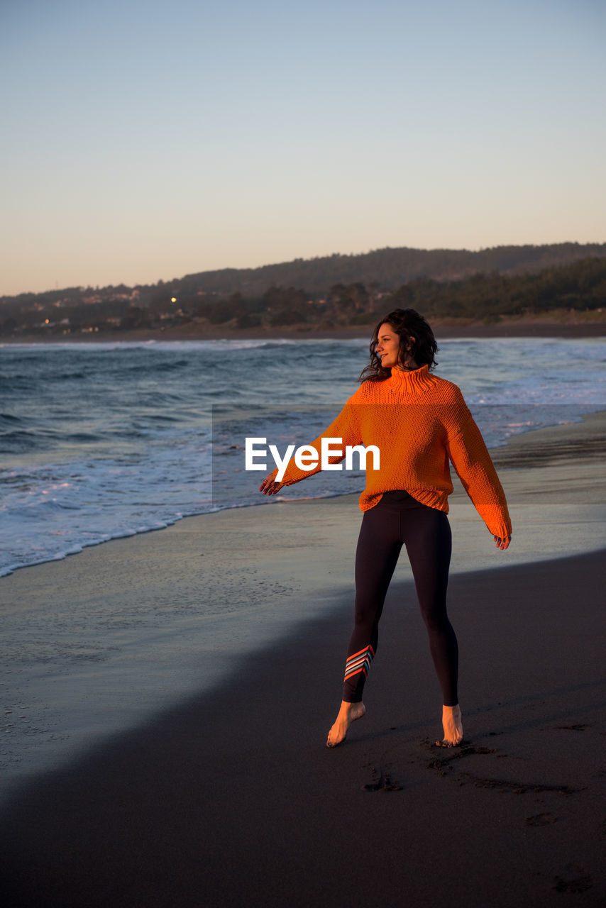 A woman appreciates the sunset along the coast