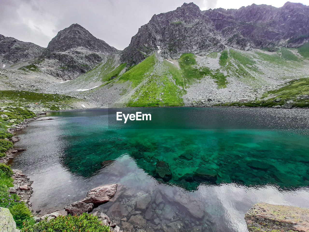 Scenic view of lake amidst mountains against sky