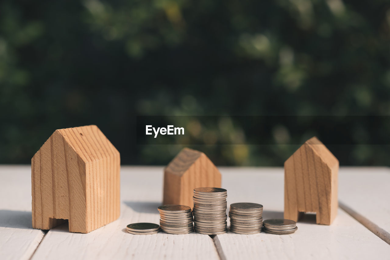 Close-up of model houses and coins on table