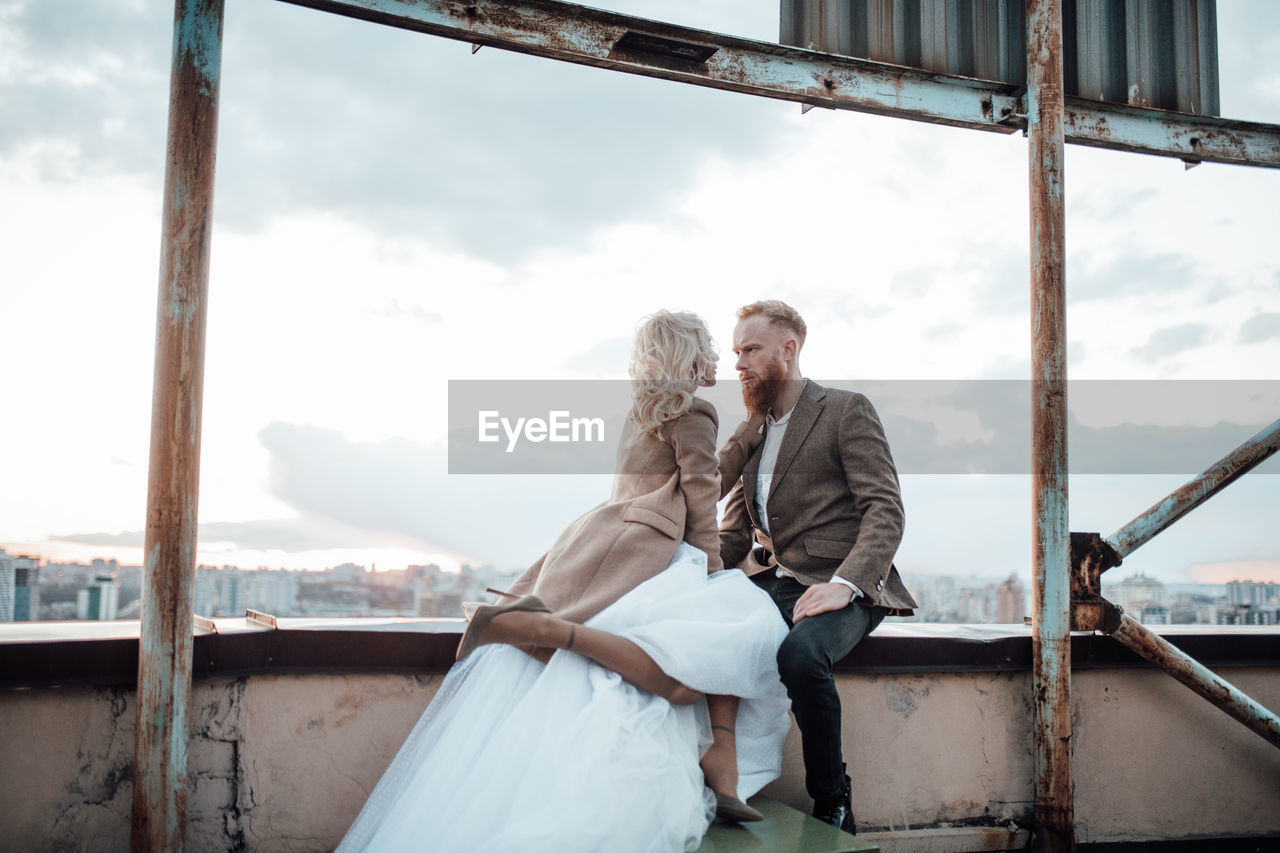 Rear view of couple standing against sky