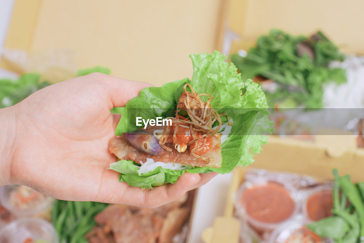CLOSE-UP OF HUMAN HAND HOLDING FOOD