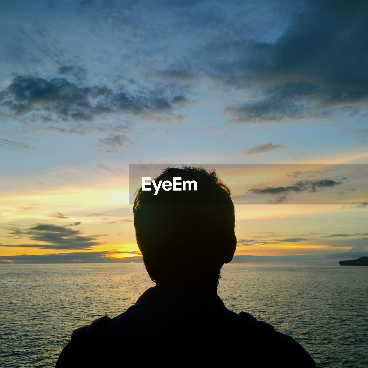 Rear view of silhouette man against sea during sunset