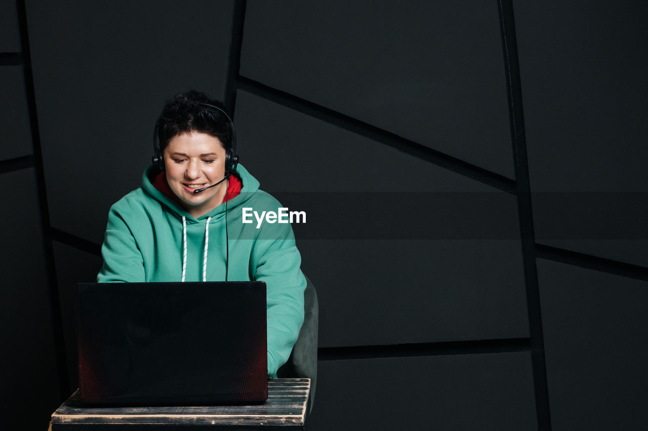 SMILING YOUNG WOMAN USING LAPTOP