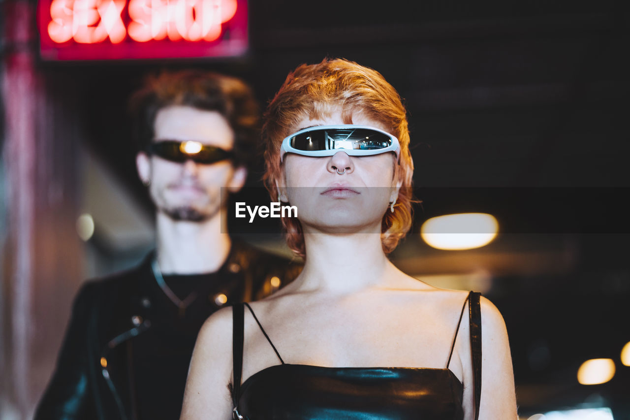 Young woman wearing smart glasses with boyfriend in background