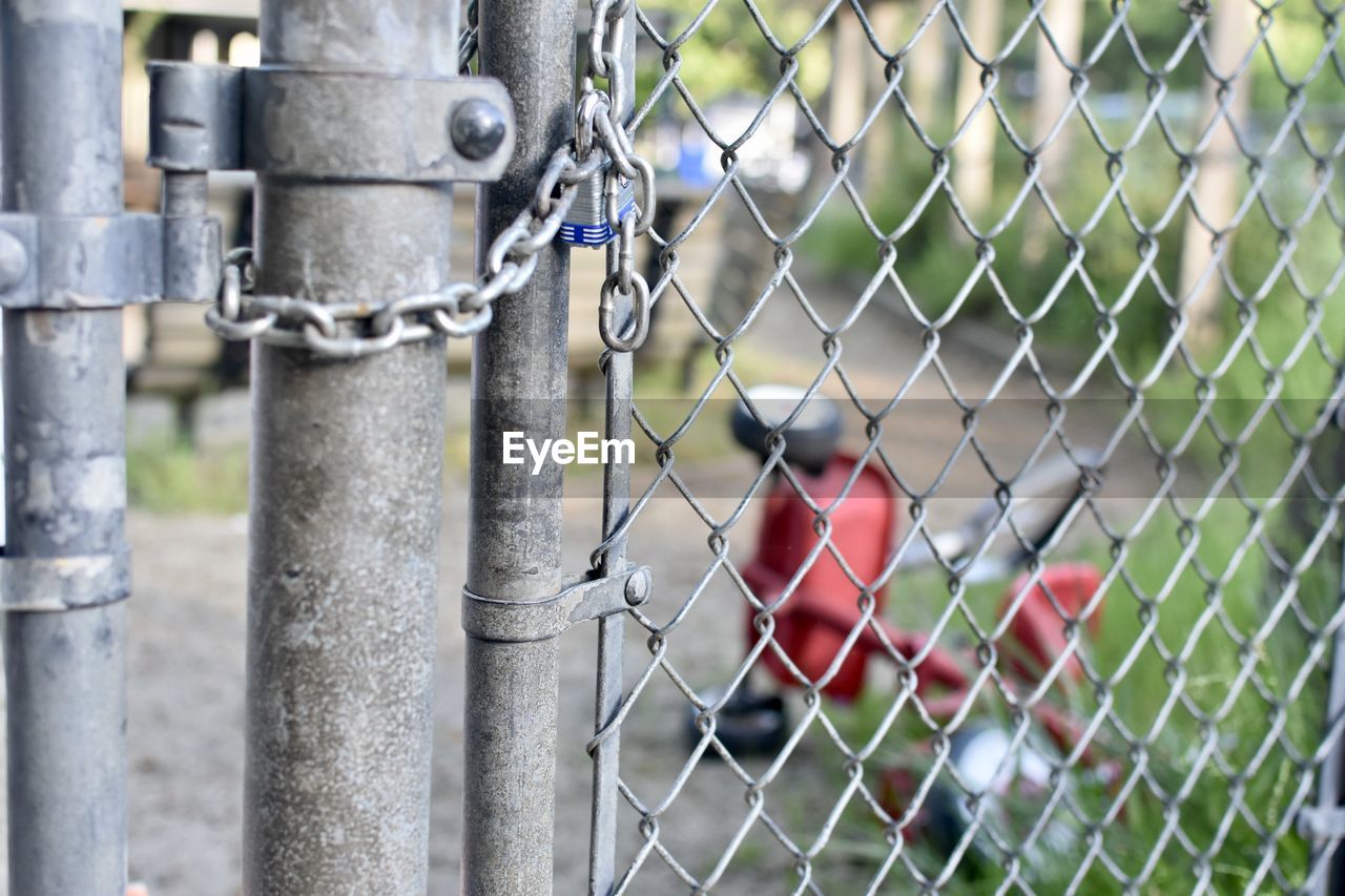 CLOSE-UP OF CHAINLINK FENCE AGAINST BLUE SKY