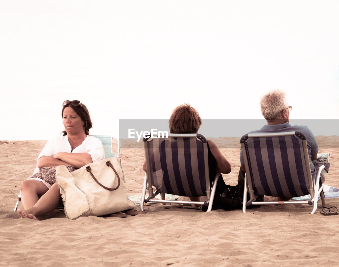 WOMAN SITTING ON BEACH