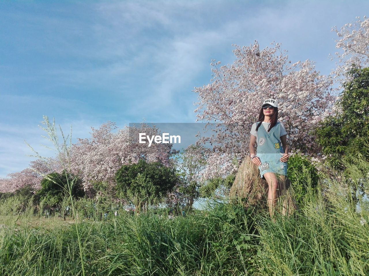 Woman standing on grassy field against sky