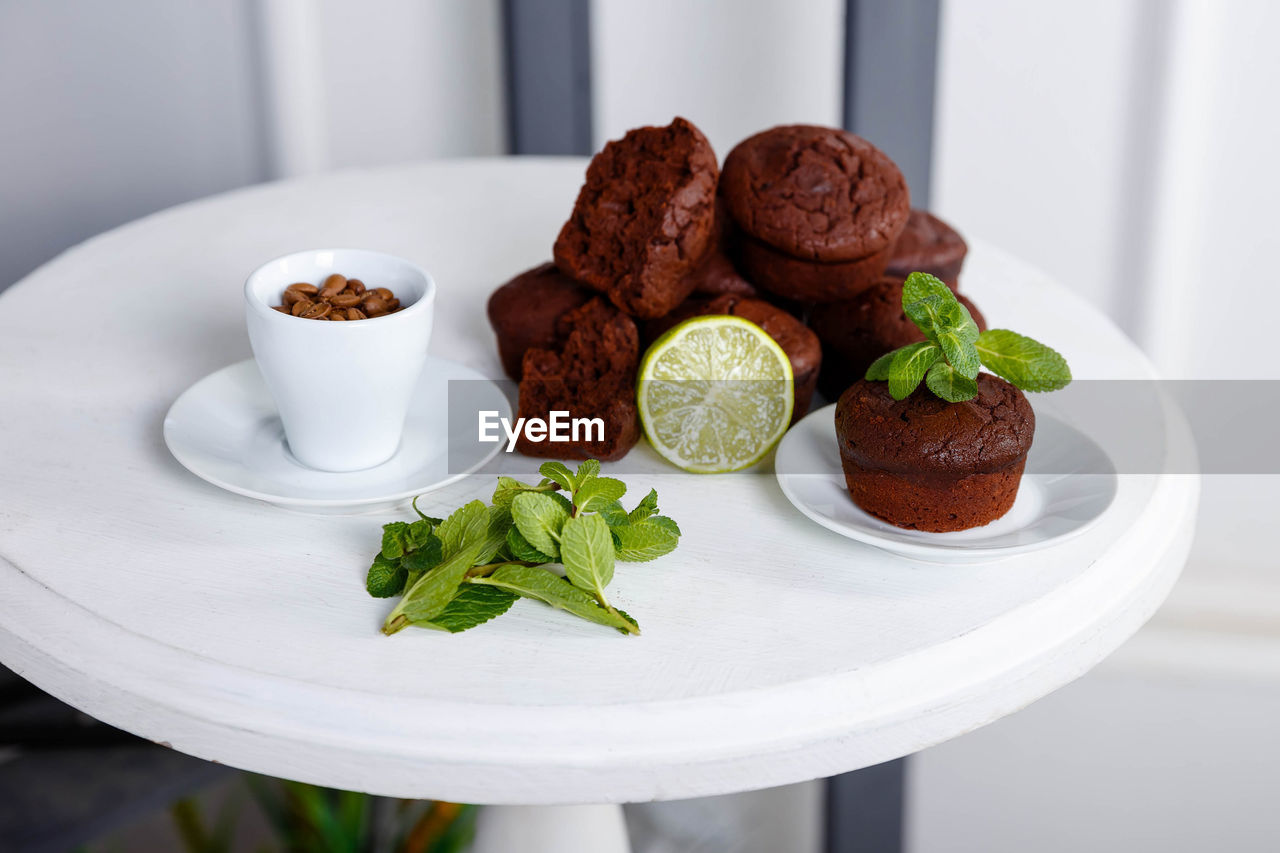 Chocolate cupcakes with coffee beans on a white wooden table