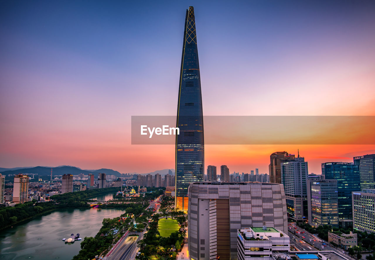 Buildings in city against sky during sunset