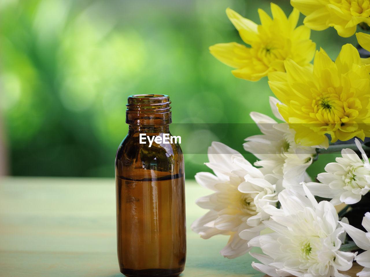 flower, flowering plant, plant, container, yellow, beauty in nature, bottle, freshness, nature, flower head, glass, close-up, no people, fragility, therapy, aromatherapy, jar, indoors, inflorescence, focus on foreground, arrangement, petal, green, glass bottle, macro photography