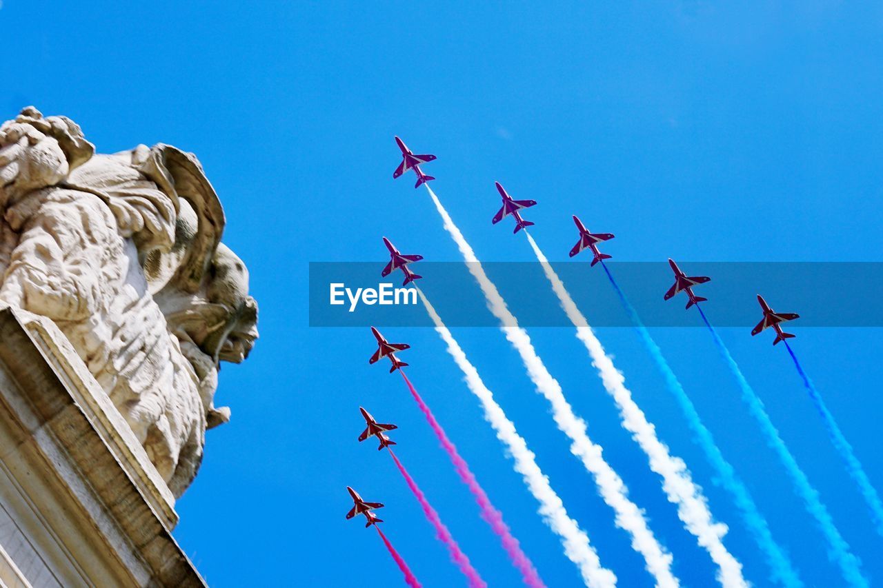 Low angle view of airplane flying against clear blue sky