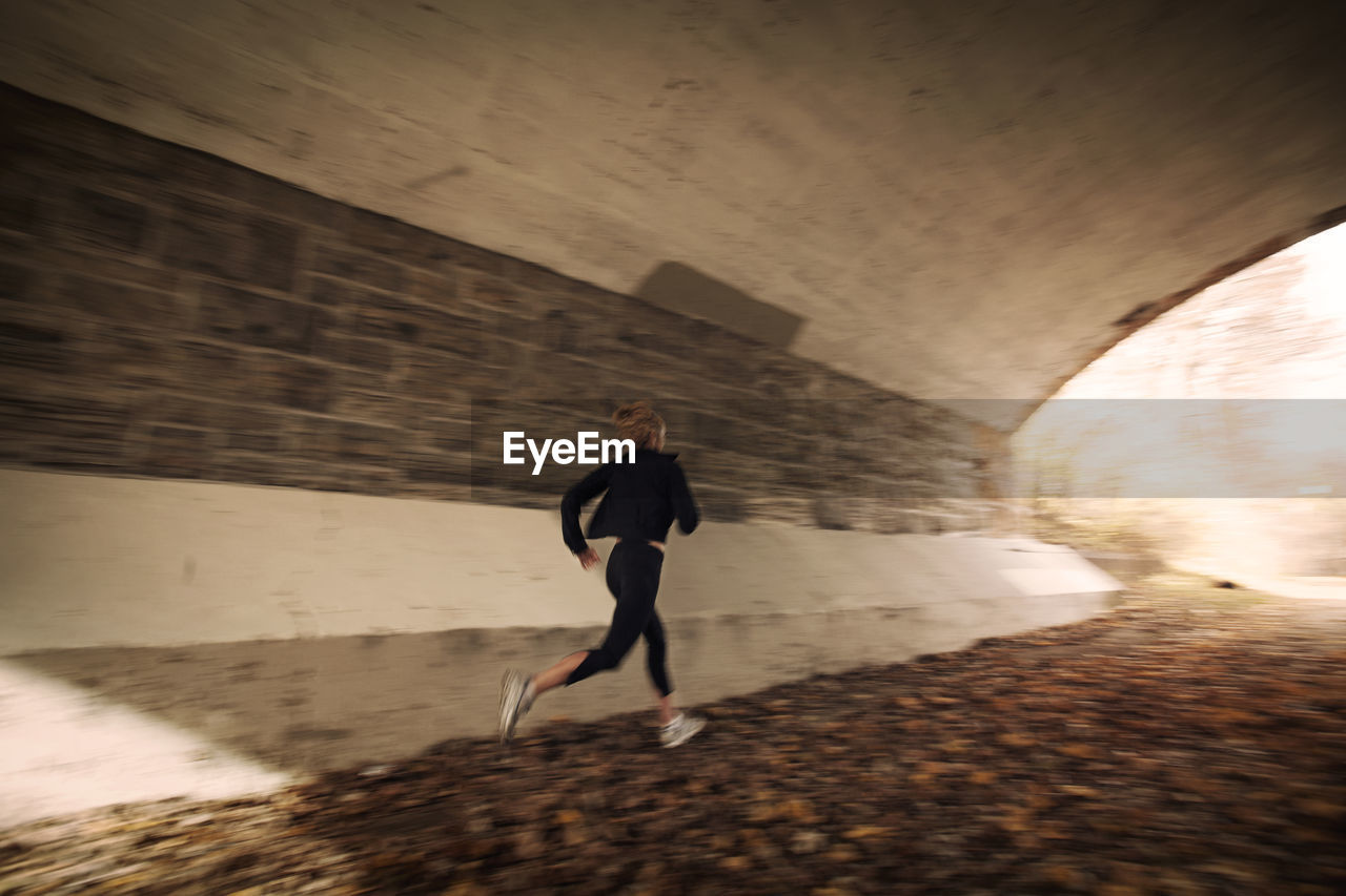 Woman jogging in old tunnel