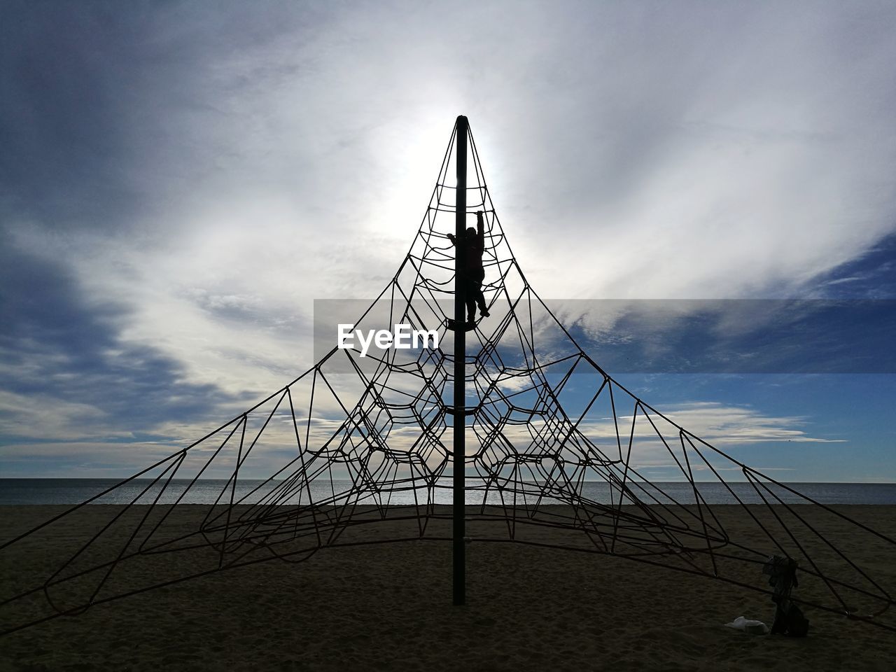 Low angle view of silhouette chain swing ride against sky