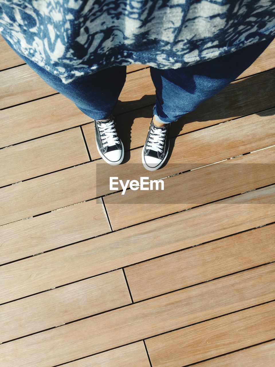 HIGH ANGLE VIEW OF MAN STANDING ON HARDWOOD FLOOR