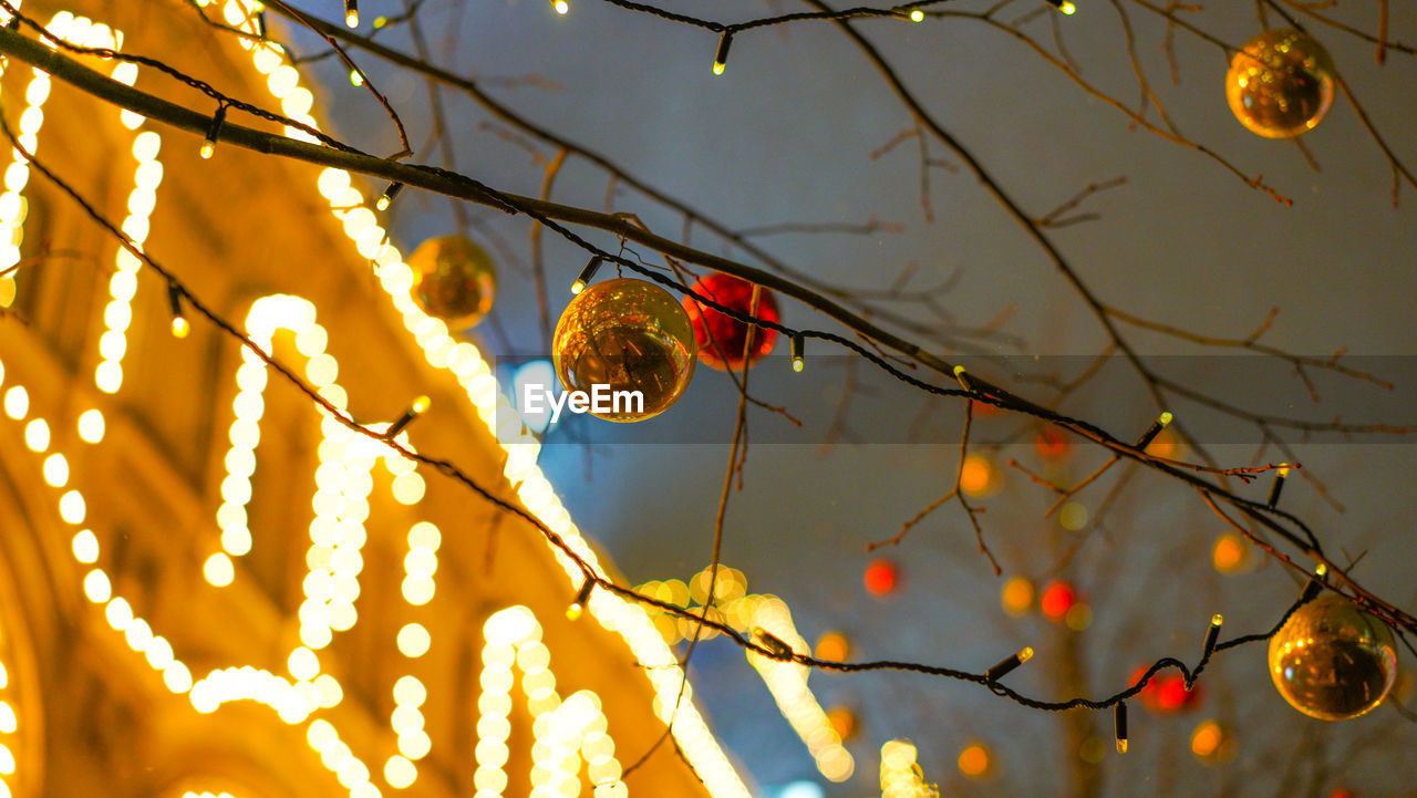 LOW ANGLE VIEW OF CHRISTMAS DECORATION HANGING FROM TREE