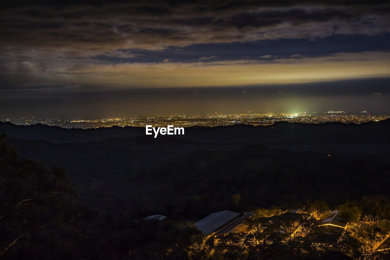 Aerial view of illuminated city against sky at sunset