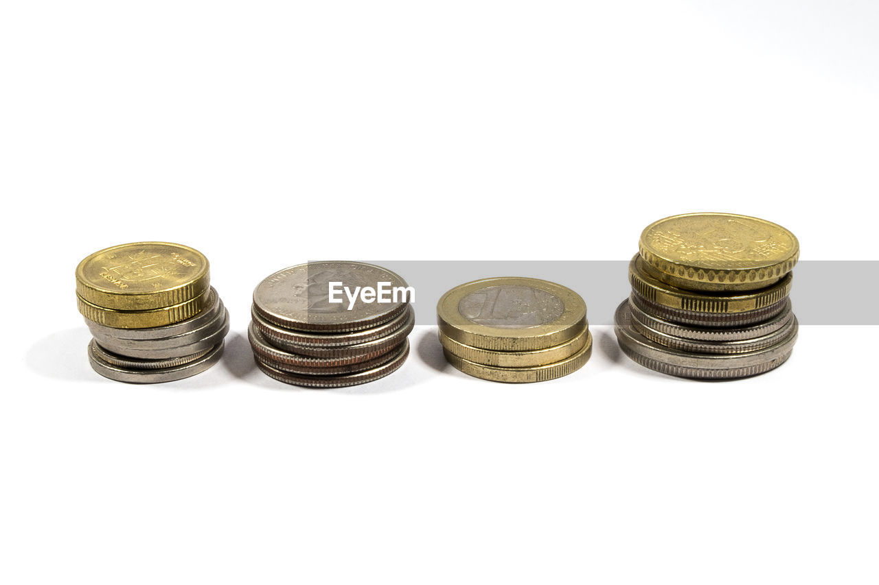 Many coins from different countries in column on white background