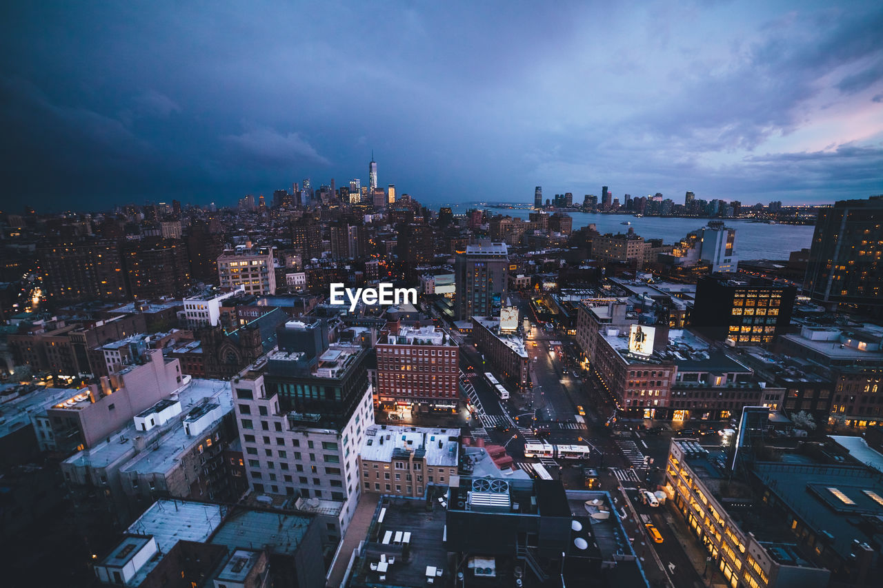 Cityscape against cloudy sky at dusk