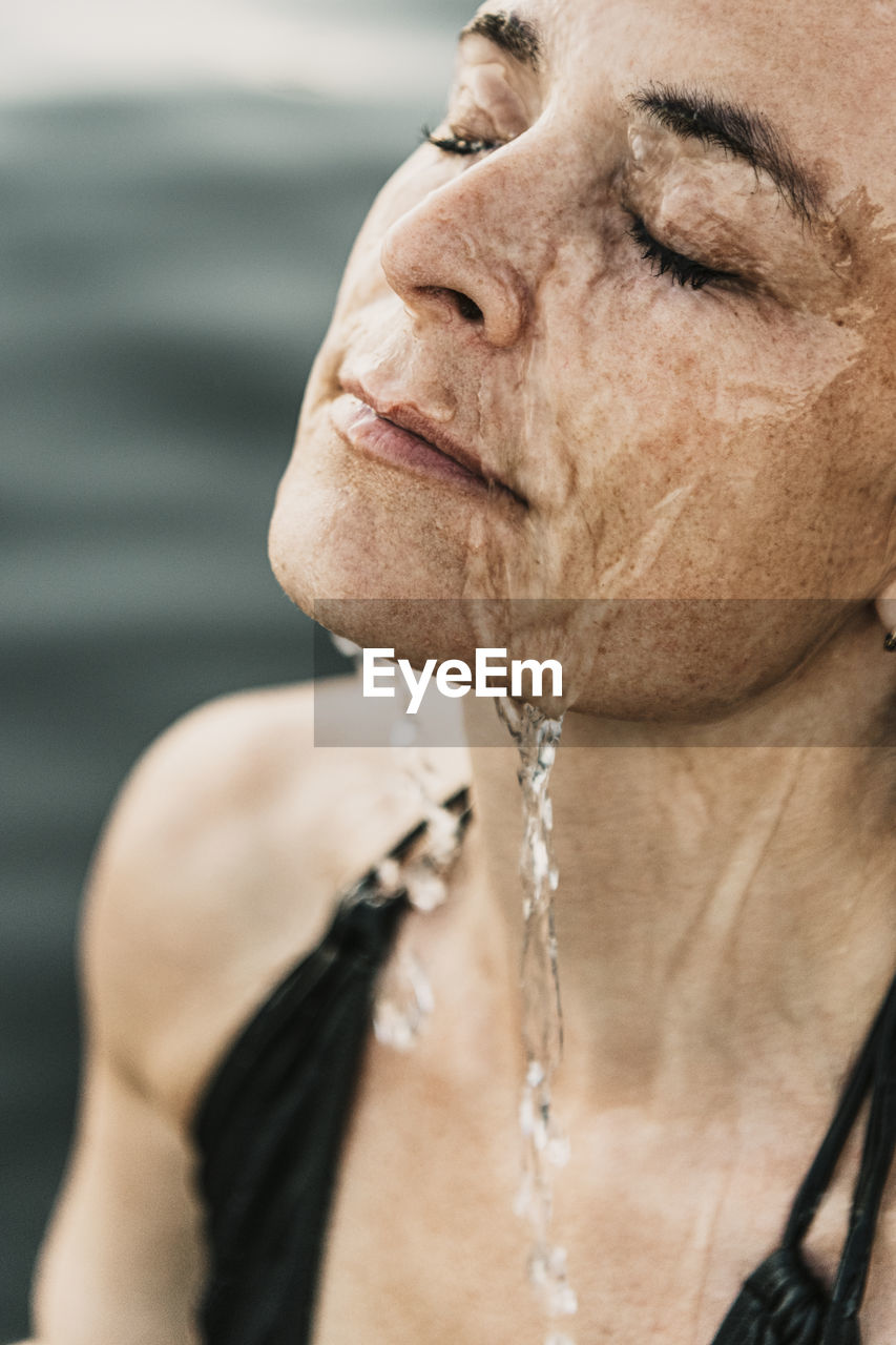 Mature woman with water on face