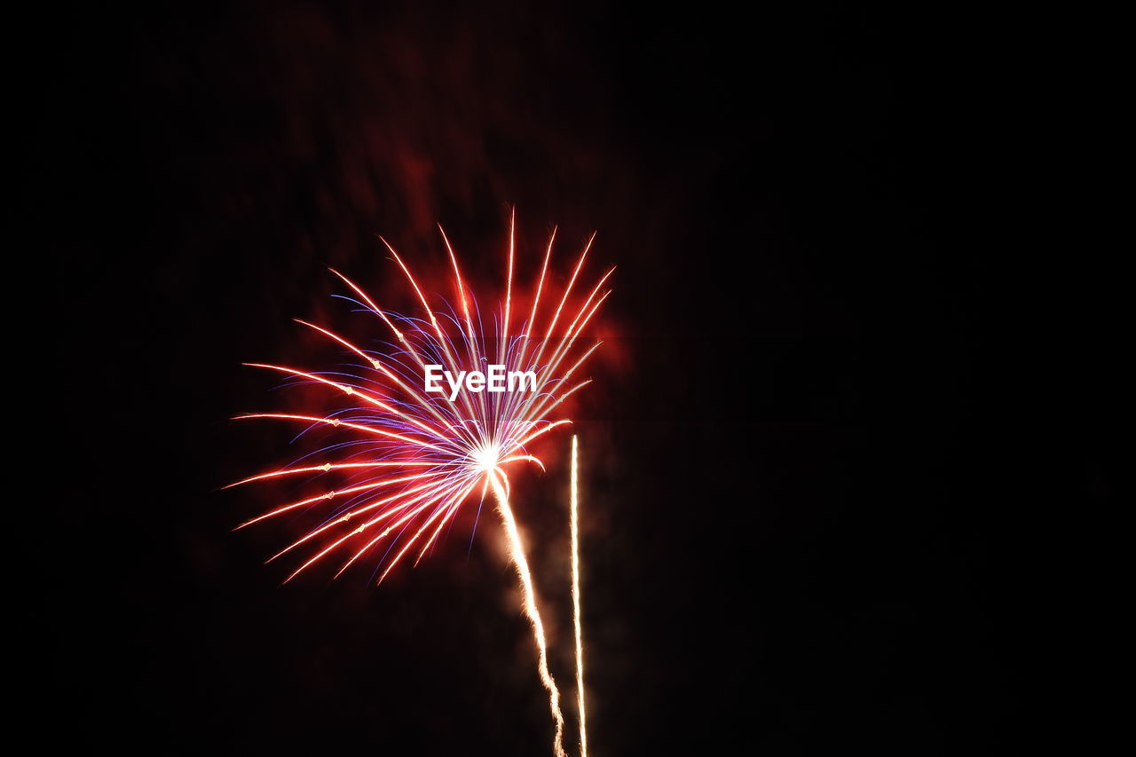 Low angle view of firework display at night