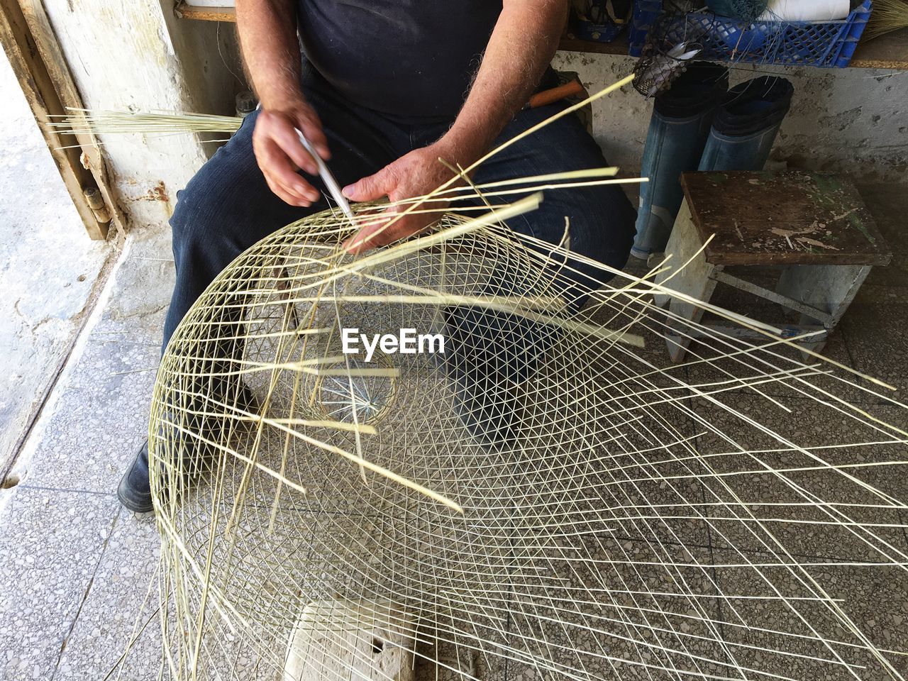 Low section of man making wicker basket