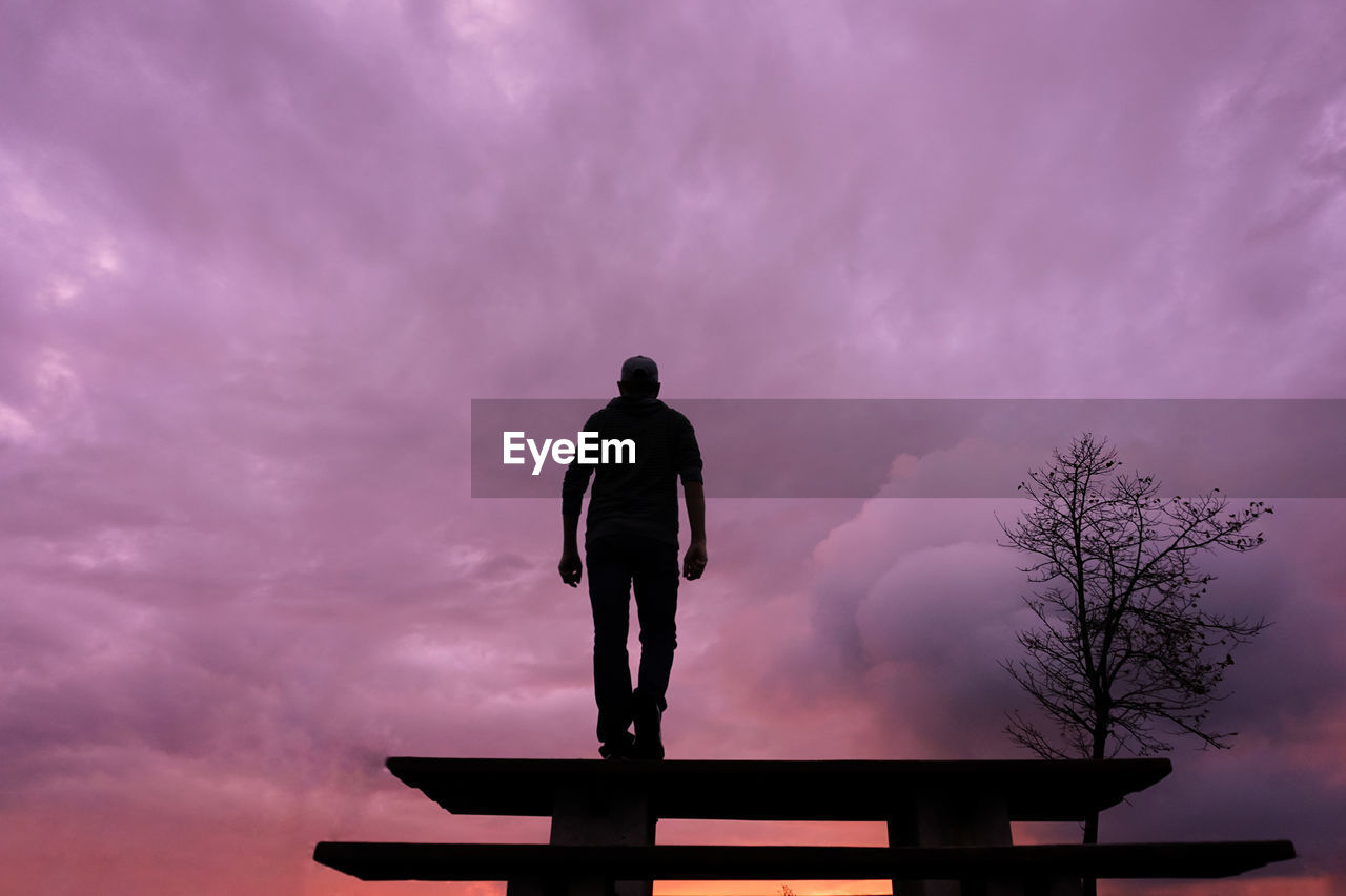 sky, silhouette, cloud, one person, nature, standing, sunset, full length, architecture, adult, dusk, dramatic sky, men, outdoors, furniture, beauty in nature, tree, evening