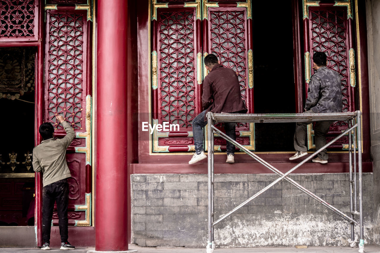 REAR VIEW OF PEOPLE AT TEMPLE