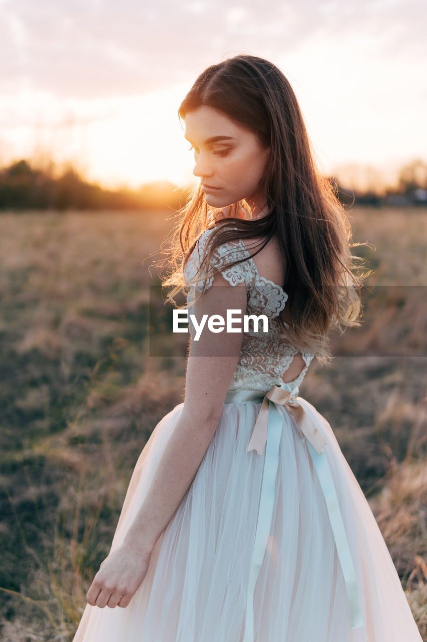 Thoughtful young woman standing on field