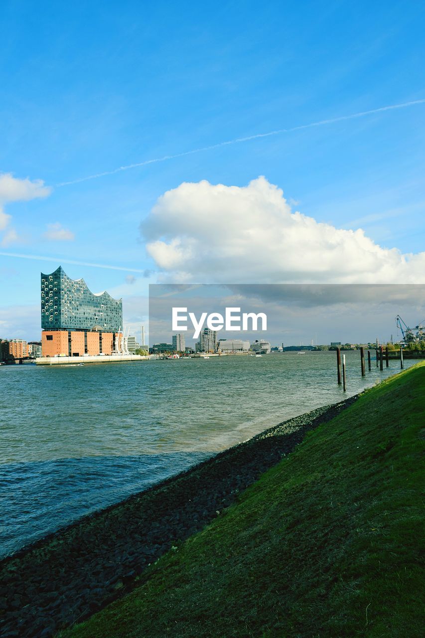 Scenic view of sea by buildings against sky