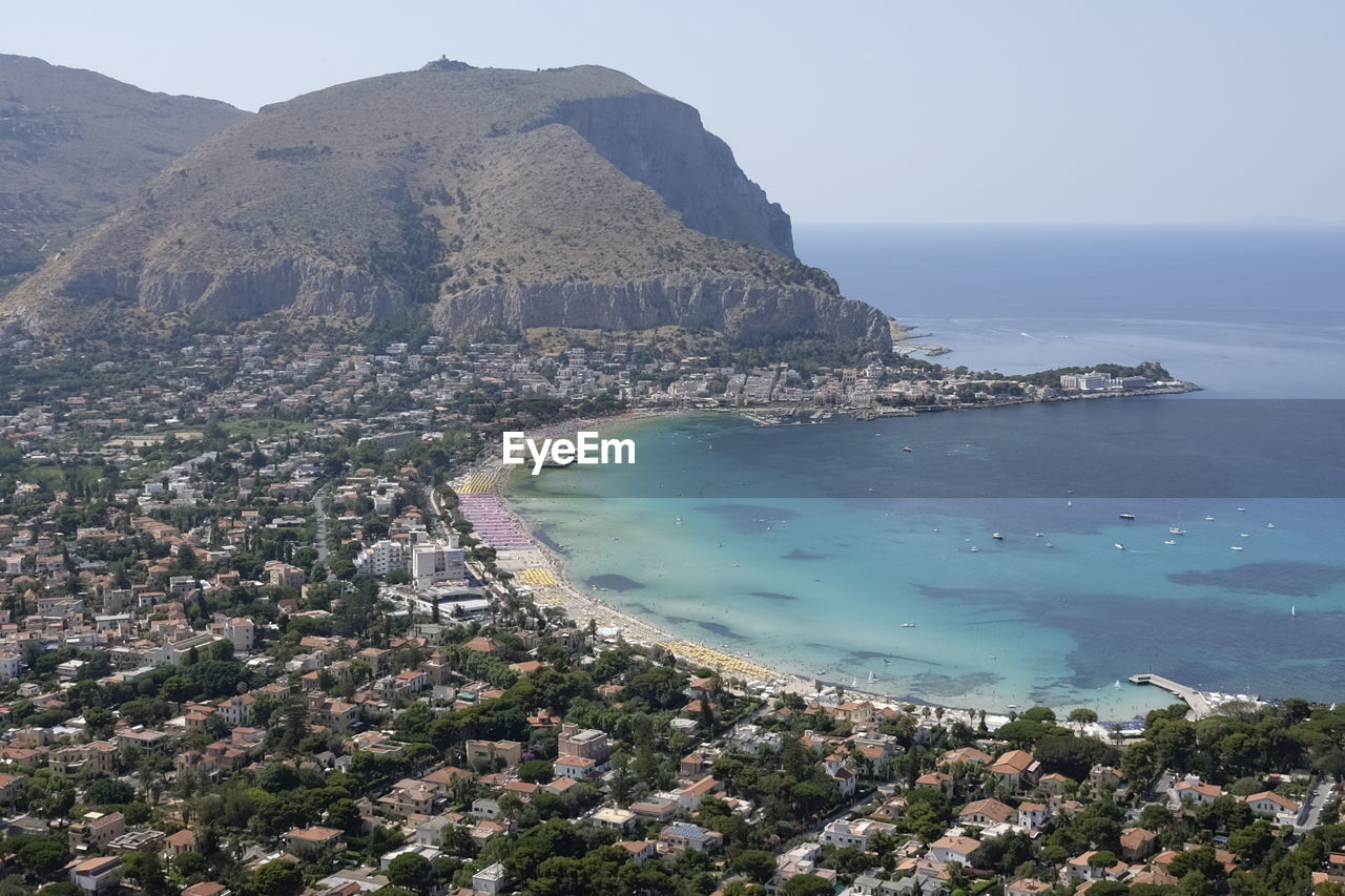 High angle view of sea and mountains against clear sky