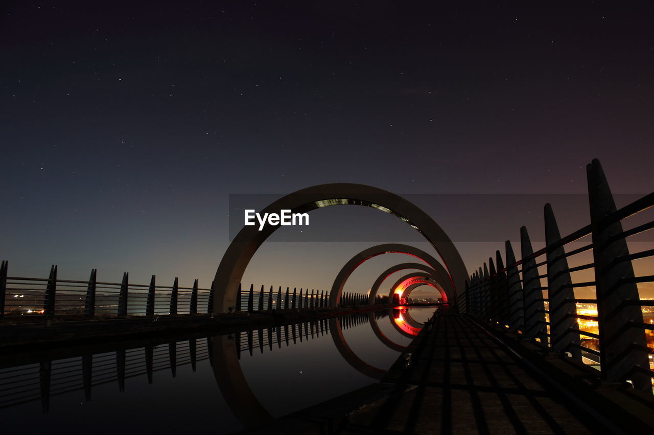 Falkirk wheel against sky at night