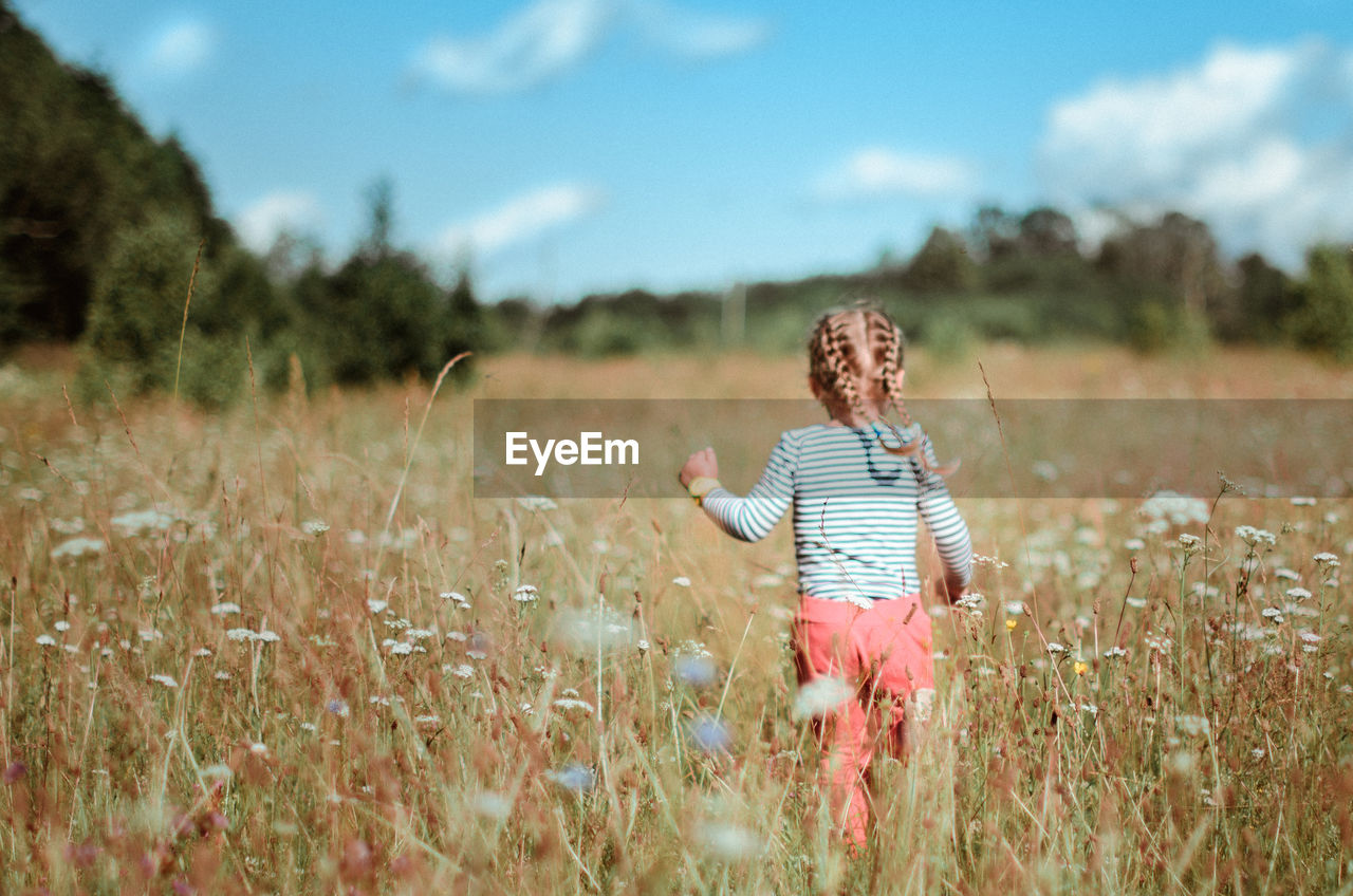 Rear view of girl on field