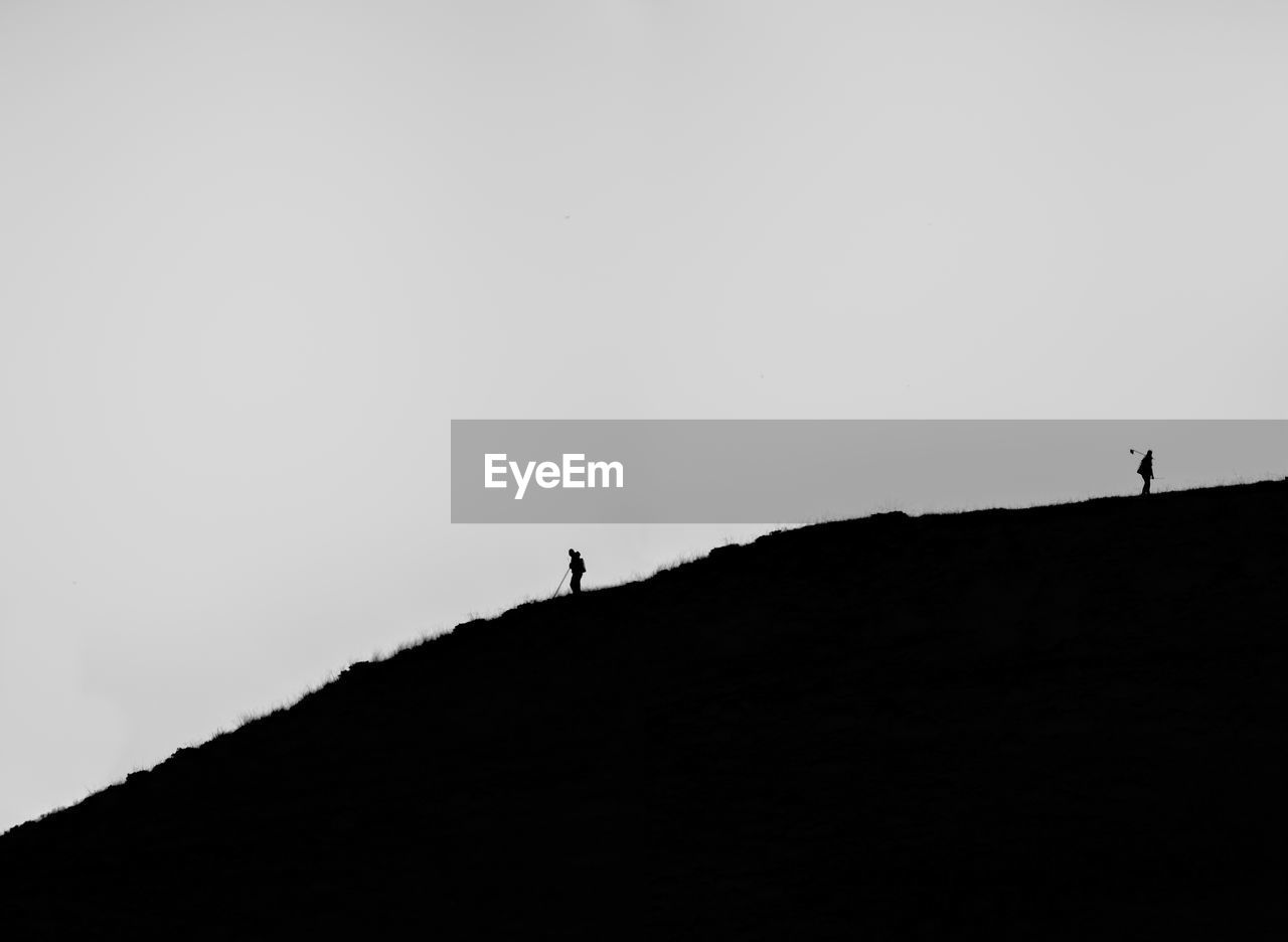 Silhouette person standing on mountain against clear sky
