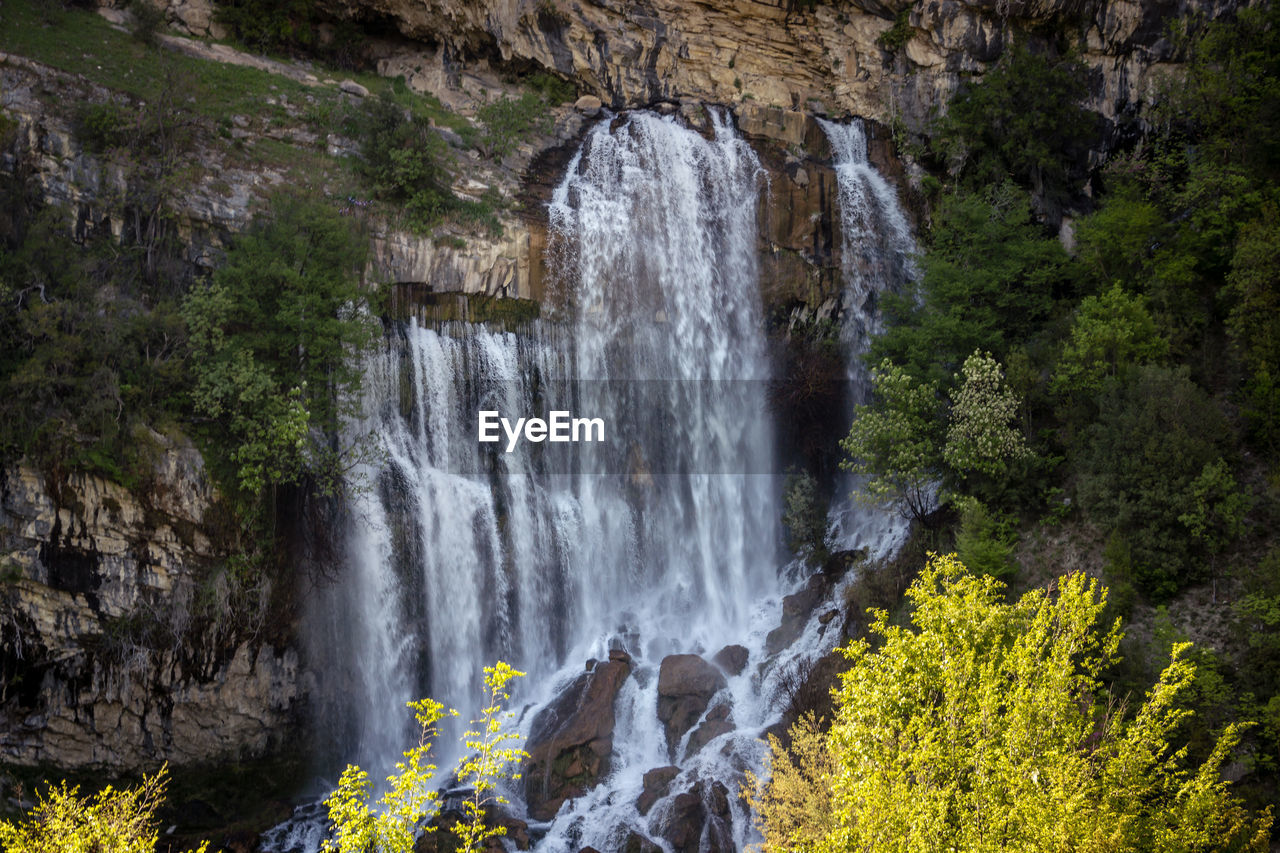 SCENIC VIEW OF WATERFALL AGAINST TREES