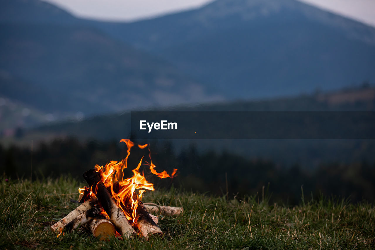 Burning bonfire in the evening in the carpathian mountains. place for inscription.