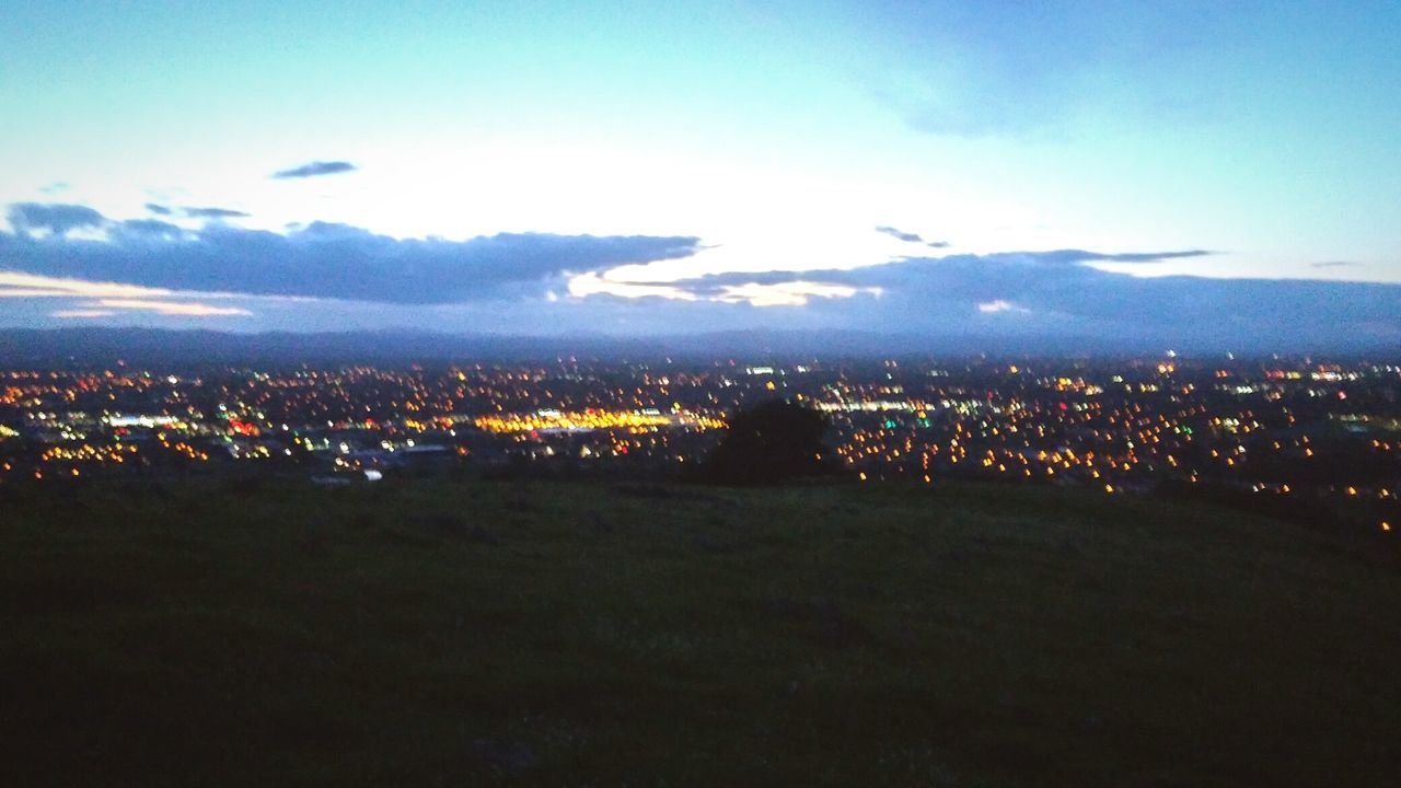 AERIAL VIEW OF CITYSCAPE AGAINST CLOUDY SKY