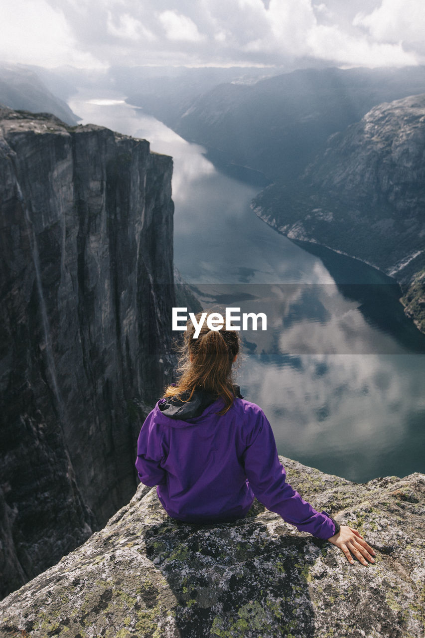 Rear view of woman looking at mountains against sky