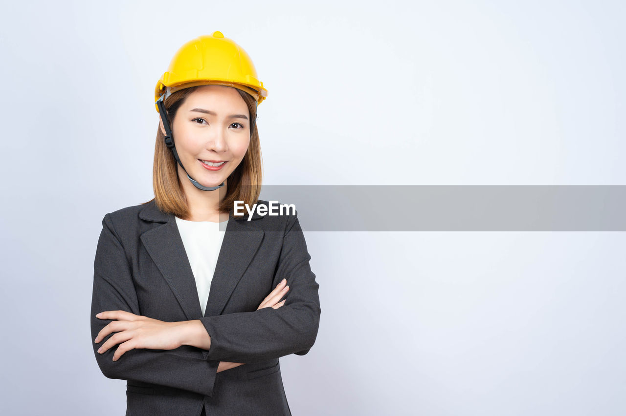 Portrait of smiling female architect over blue background