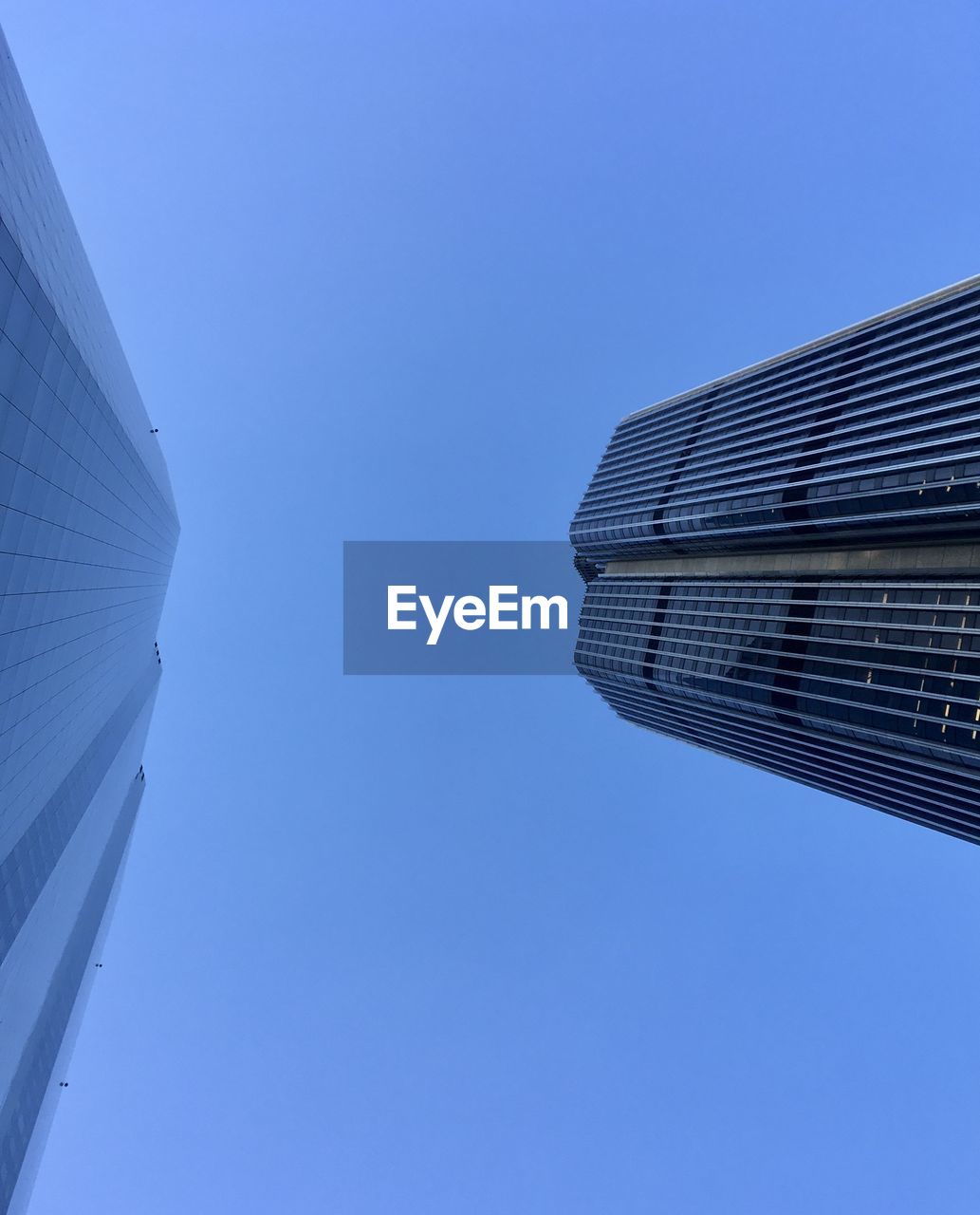 Low angle view of modern building against clear blue sky