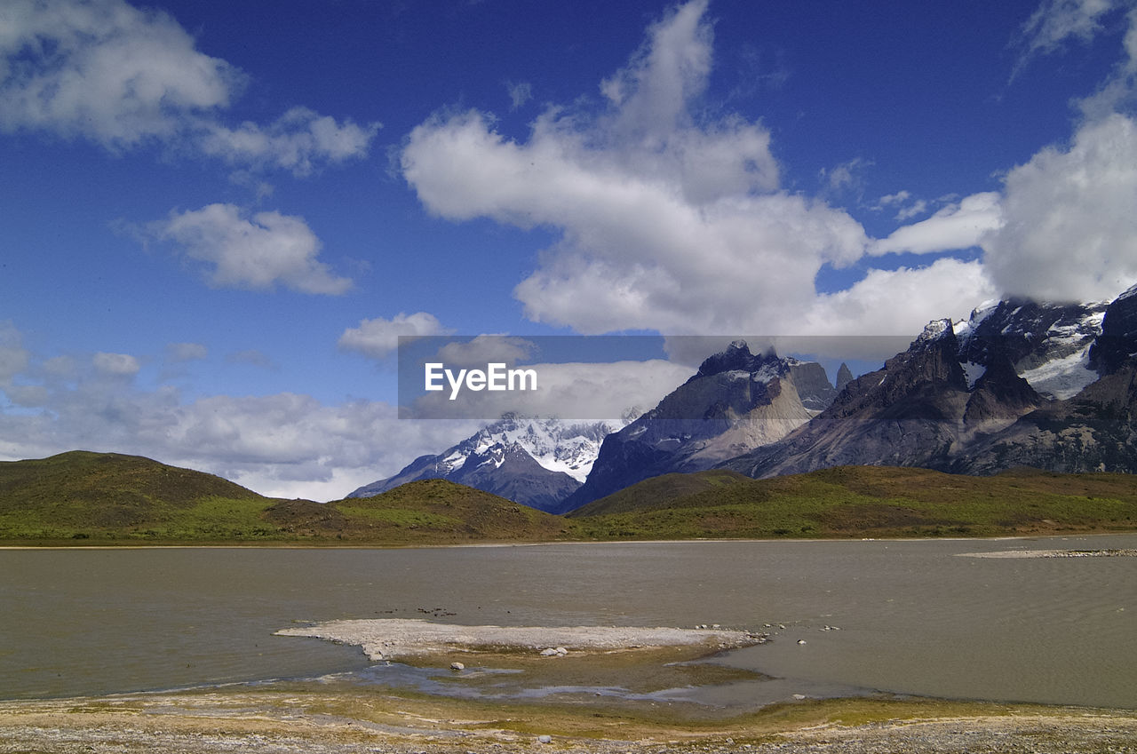 Scenic view of lake by mountains against sky