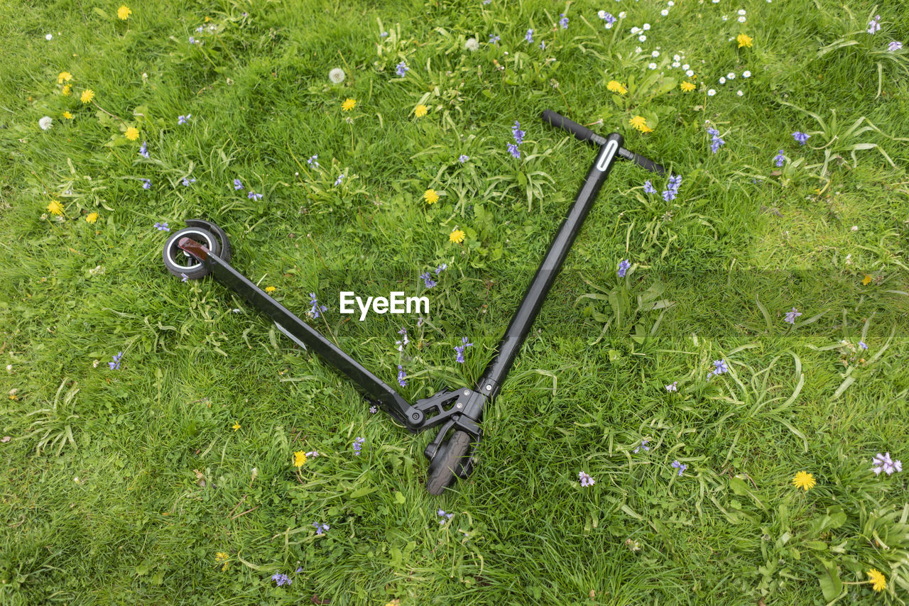 E-scooter lying on flower meadow