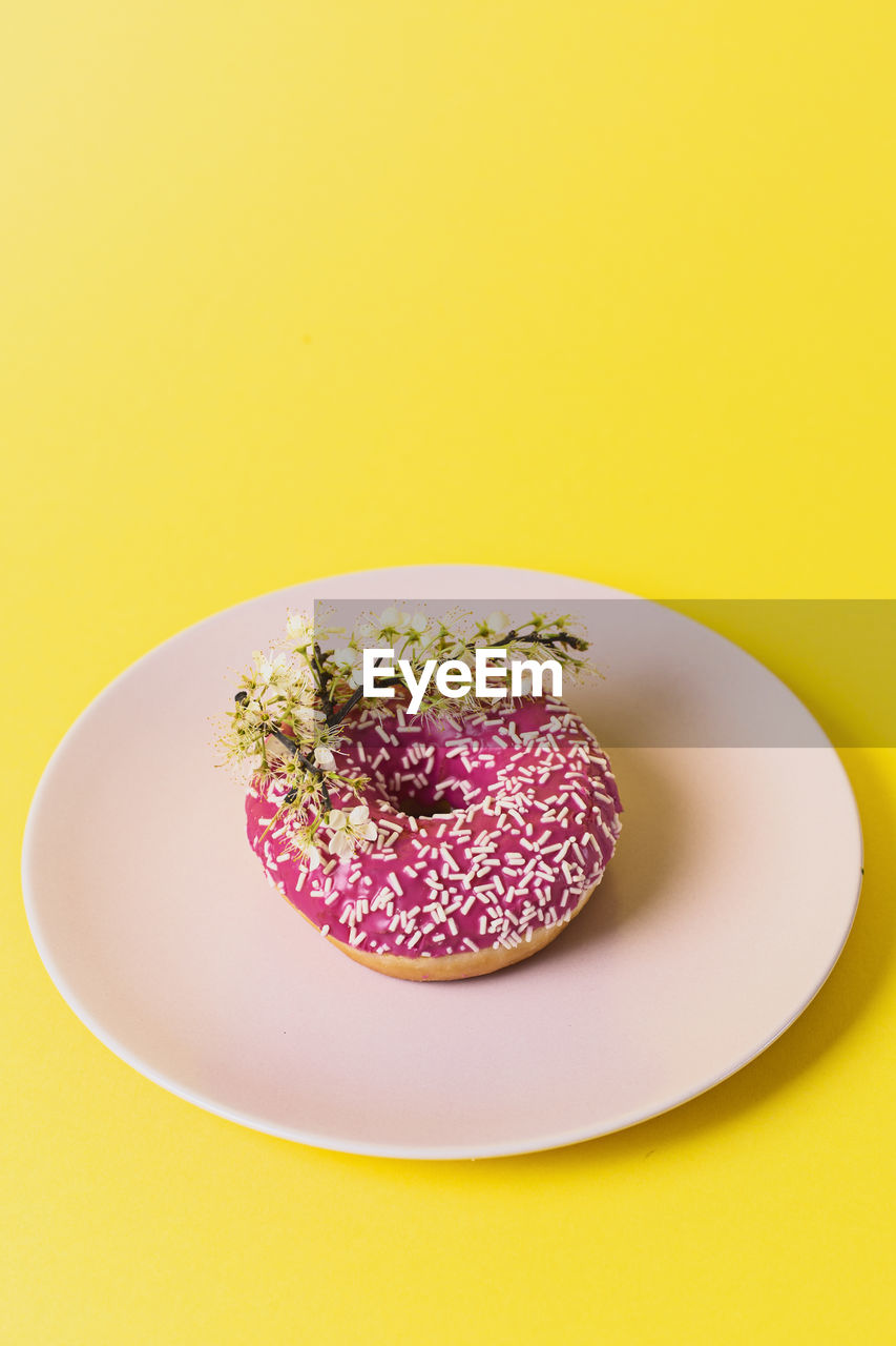 Close-up of dessert in plate on yellow background